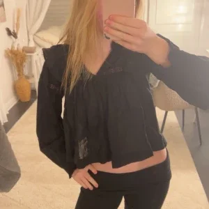 Svart blus med spetsdetaljer