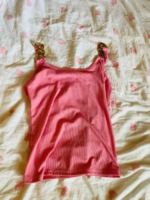 Rosa ribbad linnetopp med guldkedjor