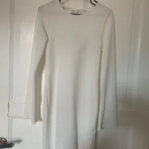Vit långärmad klänning med draperad rygg
