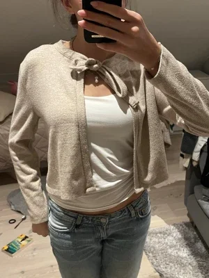 Beige cropped kofta med knytning