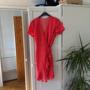Röd omlottklänning med volang från Bubbleroom