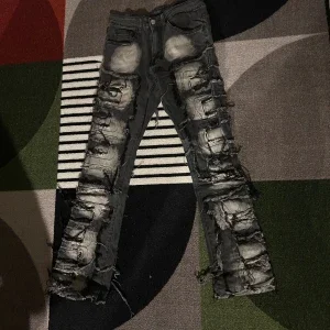 Svarta slitna jeans med trasiga detaljer