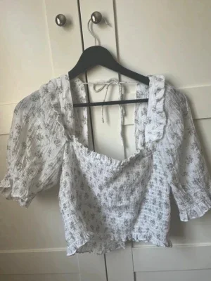 Vit blommig blus med puffärm