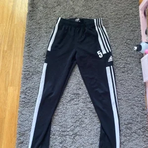 Svarta Adidas träningsbyxor med vita ränder