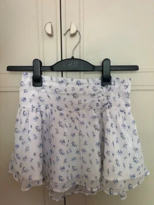 Vit kjol, detaljer-blå kjol Från gina Tricot