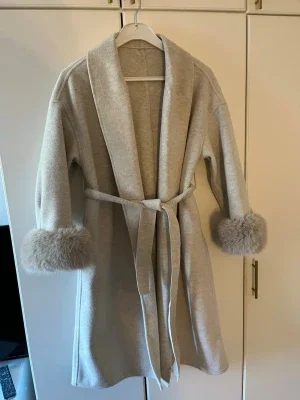 Elegant kappa med päls armar