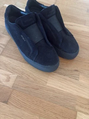 Svarta slip-on sneakers från Axel Arigato