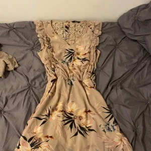 Beige blommig klänning med spets och volang