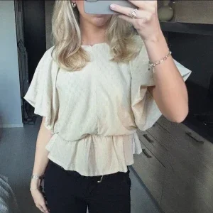 Beige blus med volang och kort ärm