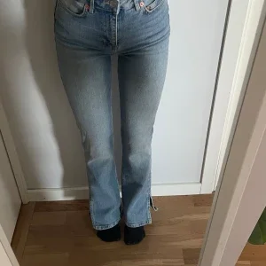 Blå jeans med slit vid foten