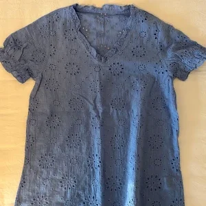Blå blus med broderade blommor