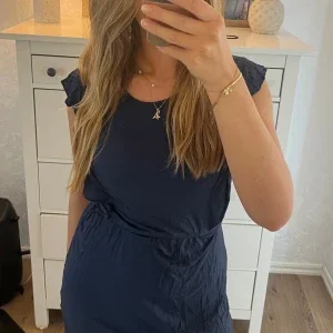 MARINBLÅ KLÄNNING MED VOLANG
