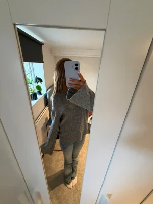 Grå stickad tröja med vida ärmar