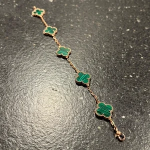 Grönt fyrklöver armband i guldton