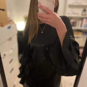 Svart blus med volangärmar