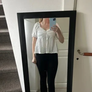 Vit blus med volang och v-ringning