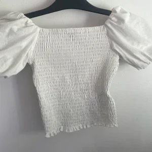 Vit smockad topp med puffärm Gina Tricot