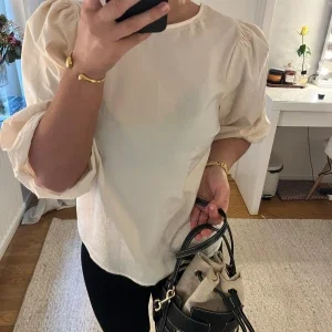 Beige blus med puffärmar och rosett i ryggen