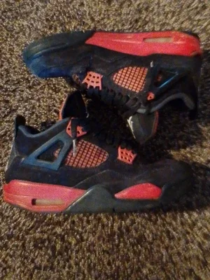 Svarta och röda Air Jordan 4 sneakers