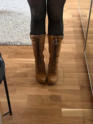 Bruna snörade höga läderstövlar