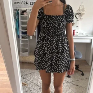 Svart blommig kortklänning med inbyggda skorts