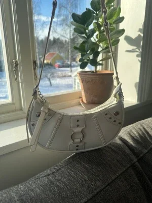 Vit axelremsväska med kedjedetaljer