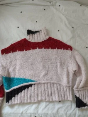 Stickad tröja i pastell och rött