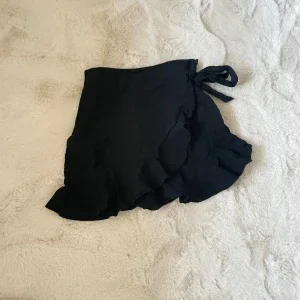 Svart omlottkjol med volang