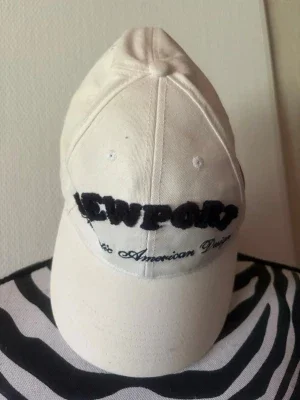 Vit Newport keps med brodyr
