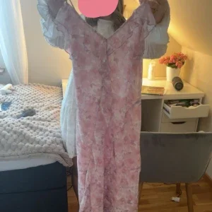 Lång blommig rosa klänning med volang från vila