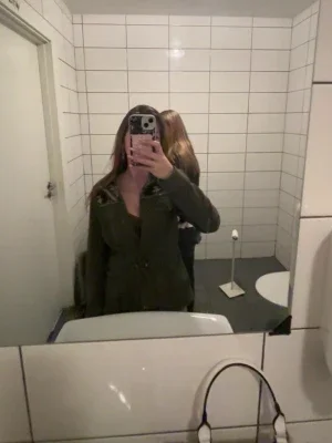 Olivgrön kappa med mönstrade axlar