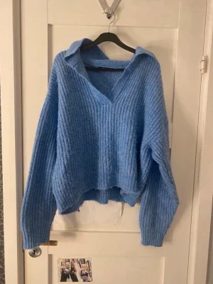 Blå stickad tröja med krage