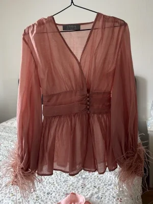Rosa transparent blus med fjädrar