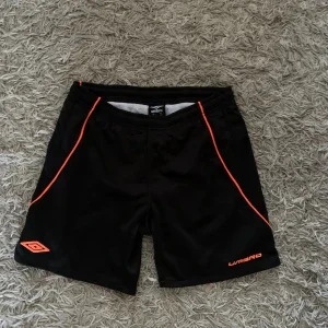 Svarta badshorts från Umbro med orange detaljer