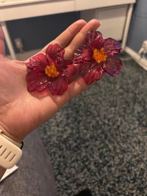 Stora blommiga örhängen i rosa plast