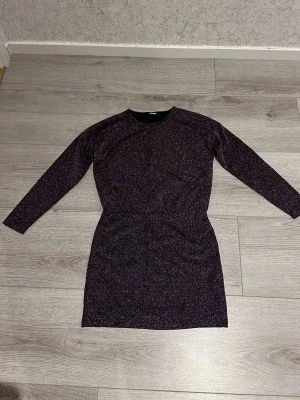 Glittrig mörk långärmad klänning