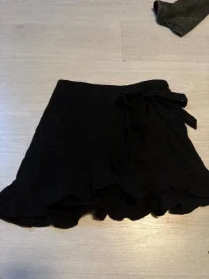 Svart omlottkjol med volang
