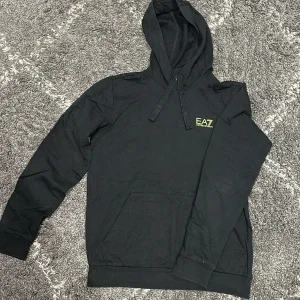 Svart EA7 hoodie med guldig logga