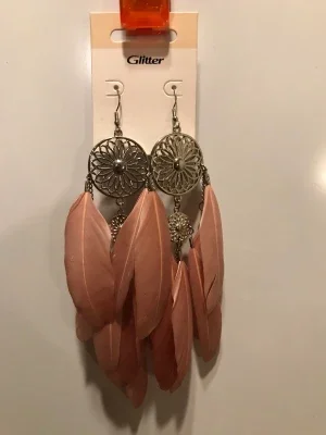 Öron hängen rosa fjädrar