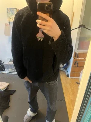 Svart fleecehoodie med Patrick-motiv