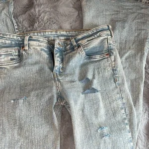 ljusblå slitna låga jeans