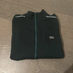 Svart tröja med dragkedja från Lacoste