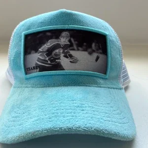 Turkos keps med hockeymotiv