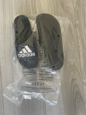 Svarta Adidas badtofflor
