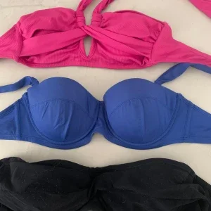 Tre bikiniöverdelar i olika färger