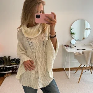 Vit stickad poncho med polokrage
