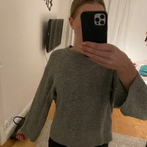 Grå stickad tröja med vida ärmar