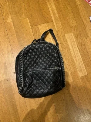 Svart ryggsäck i skinn med kedja