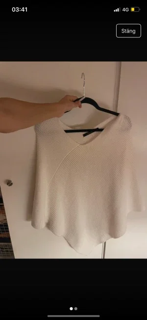Vit stickad poncho från KappAhl