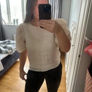 Beige blus med puffärmar